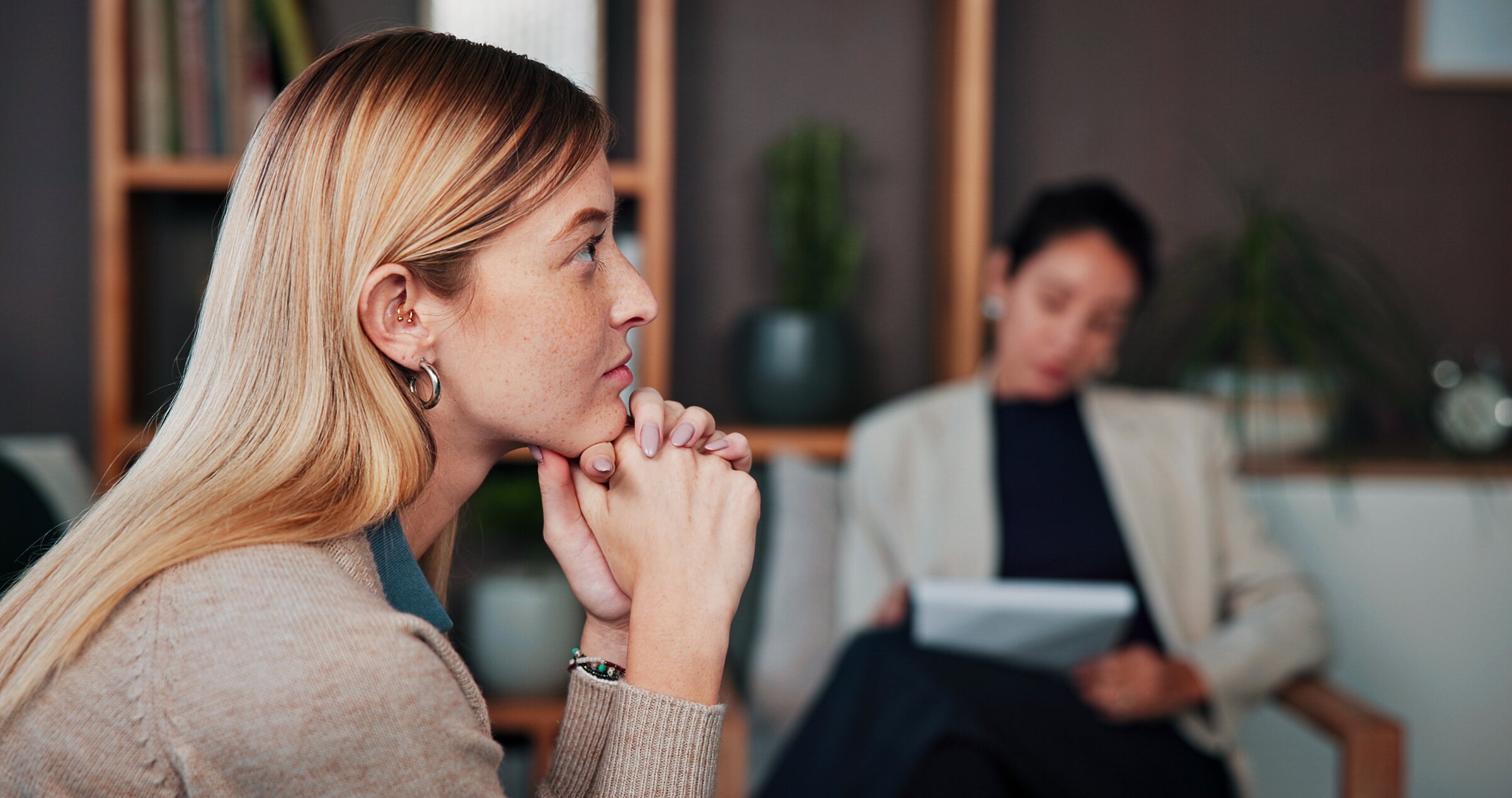 A woman looks away during a therapy session, thinking it over