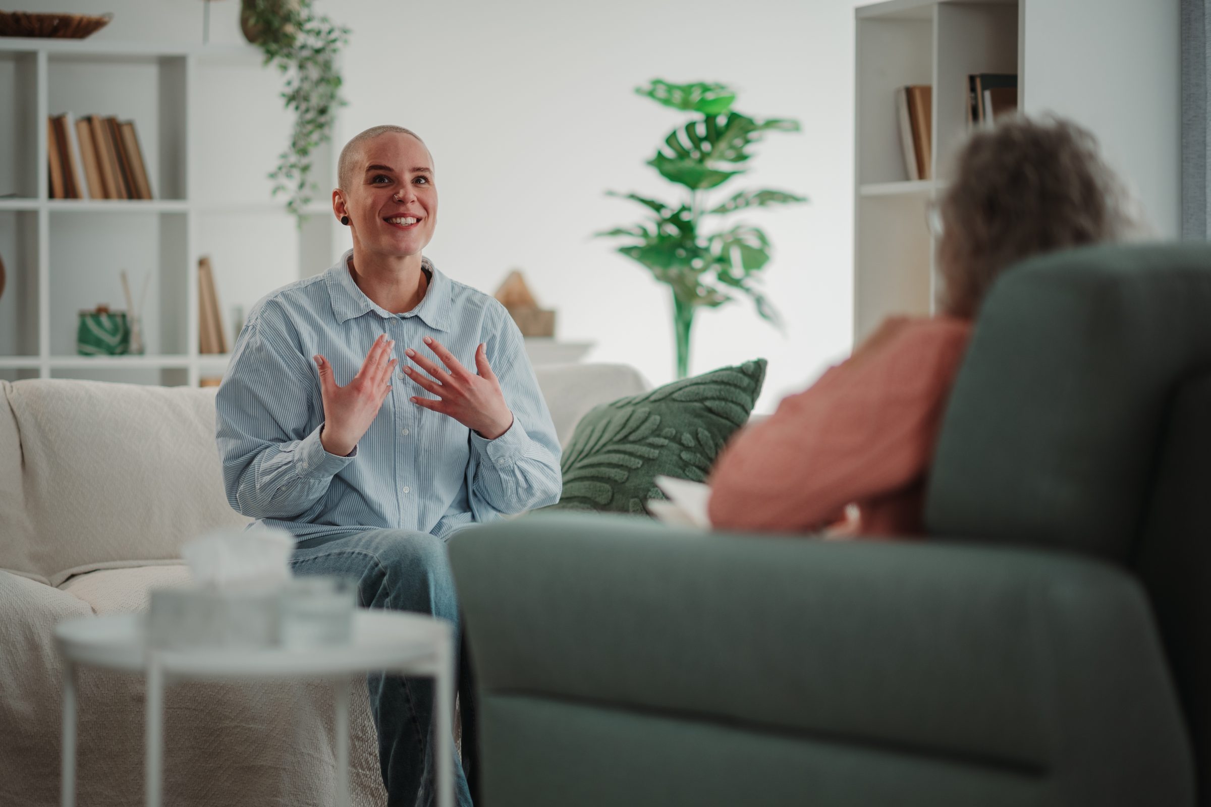 A client smiles and talks with her hands during a session with a counselor